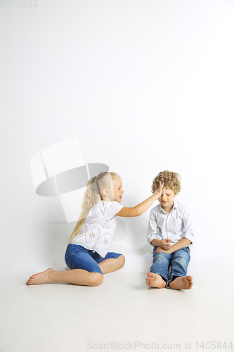 Image of Boy and girl playing together on white studio background