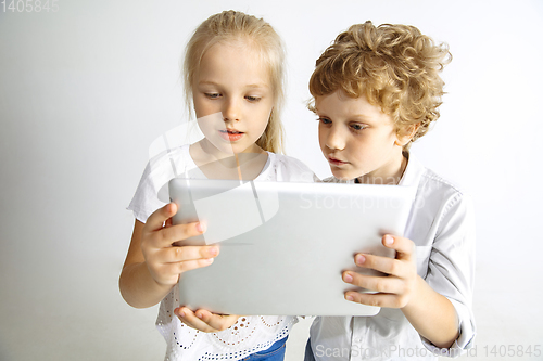 Image of Boy and girl playing together on white studio background