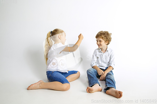 Image of Boy and girl playing together on white studio background