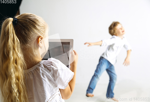 Image of Boy and girl playing together on white studio background