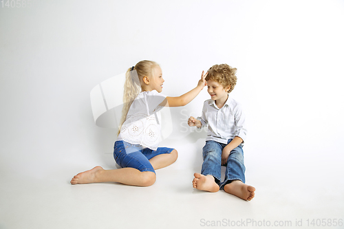 Image of Boy and girl playing together on white studio background