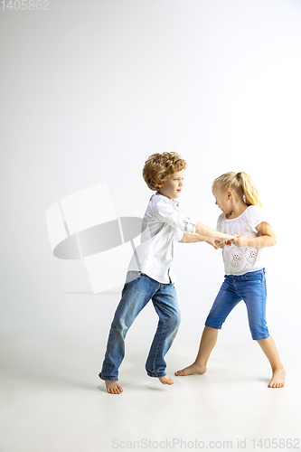 Image of Boy and girl playing together on white studio background