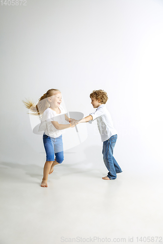 Image of Boy and girl playing together on white studio background