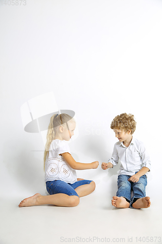 Image of Boy and girl playing together on white studio background