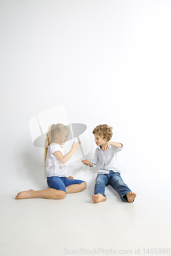 Image of Boy and girl playing together on white studio background