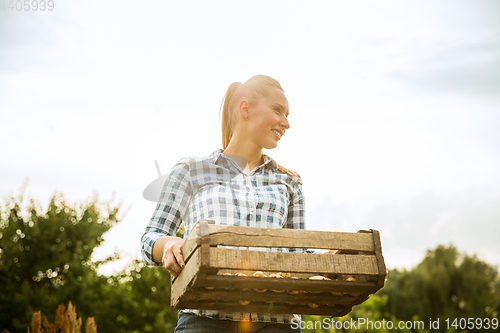 Image of Young farmer working at his garden in sunny day