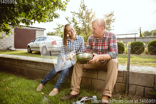 Image of Young and happy farmer\'s couple at their garden in sunny day