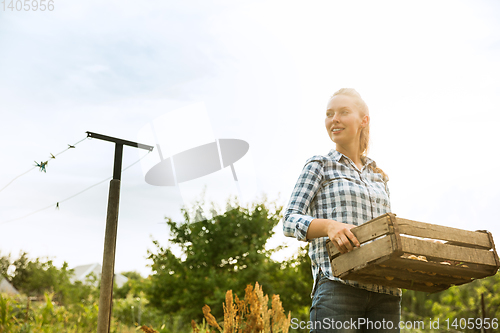 Image of Young farmer working at his garden in sunny day