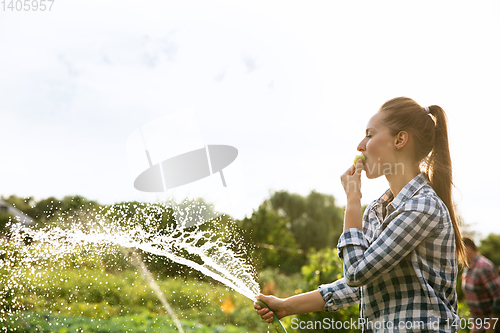 Image of Young farmer working at his garden in sunny day