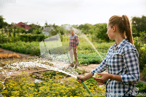 Image of Young and happy farmer\'s couple at their garden in sunny day