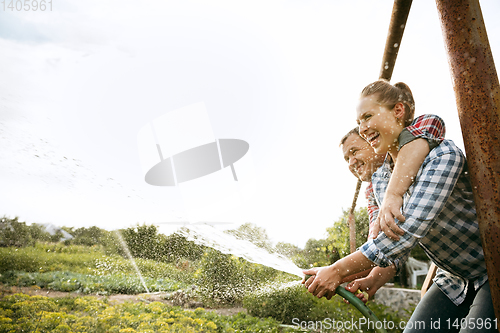 Image of Young and happy farmer\'s couple at their garden in sunny day