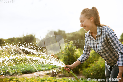 Image of Young farmer working at his garden in sunny day