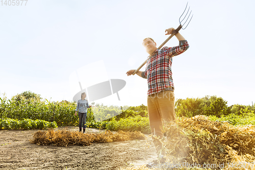 Image of Young and happy farmer\'s couple at their garden in sunny day