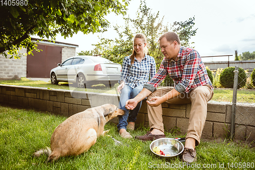 Image of Young and happy farmer\'s couple at their garden in sunny day