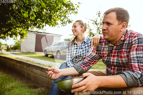 Image of Young and happy farmer\'s couple at their garden in sunny day