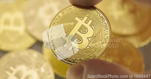 Image of Inspecting Physical bitcoin held in hands closeup