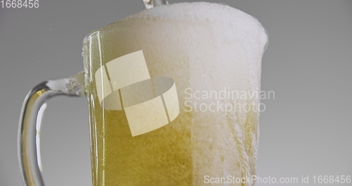 Image of Beer overflowing from large mug 120fps slow motion footage