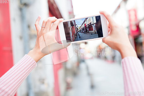 Image of Woman taking photo on cellphone in Macau