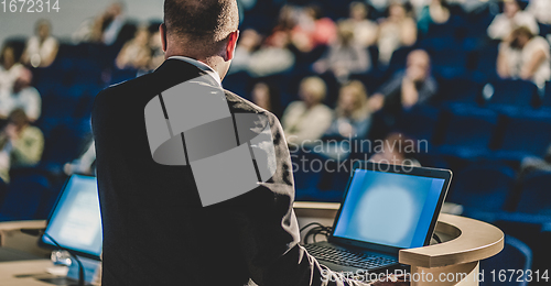 Image of Public speaker giving talk at business event.