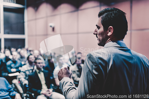 Image of Public speaker giving talk at business event.