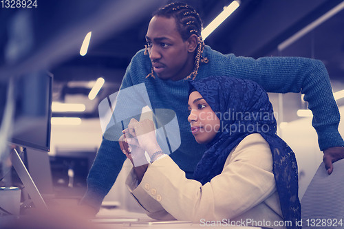 Image of young black muslim female software developer at work