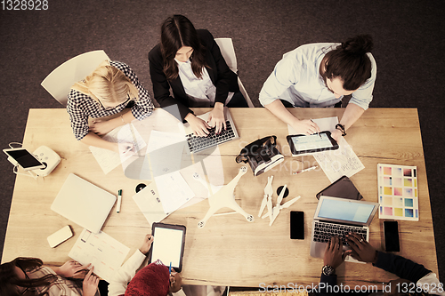 Image of top view of multiethnic business team learning about drone techn