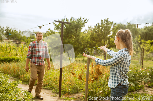 Image of Young and happy farmer\'s couple at their garden in sunny day