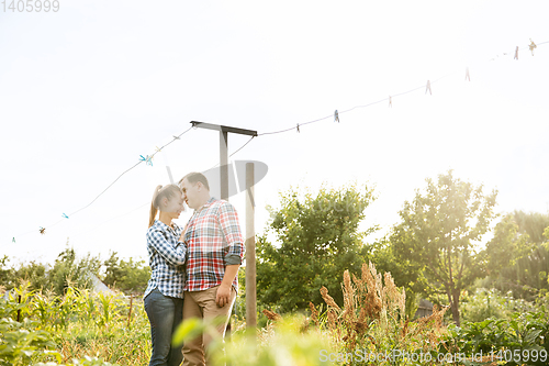 Image of Young and happy farmer\'s couple at their garden in sunny day