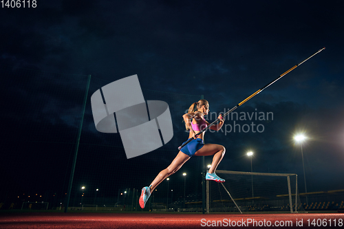 Image of Female pole vaulter training at the stadium in the evening