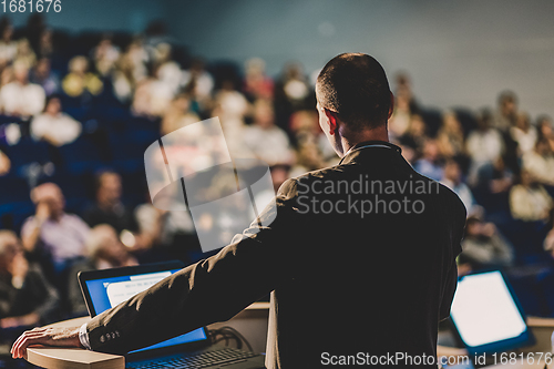 Image of Public speaker giving talk at business event.