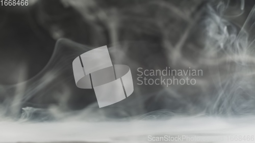 Image of Smoke cloud whirling against dark background slow motion footage