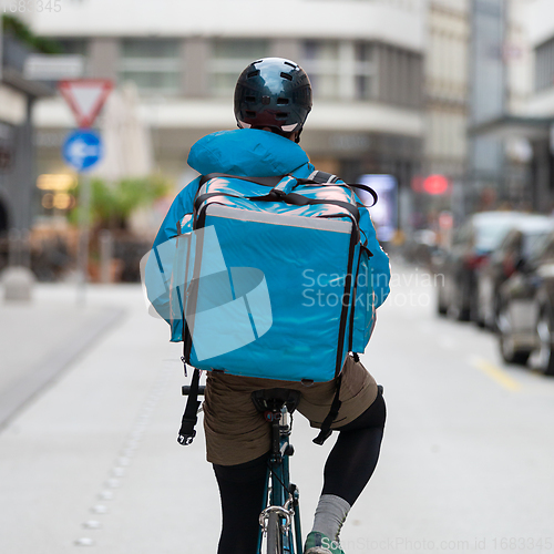 Image of Courier On Bicycle Delivering Food In City.