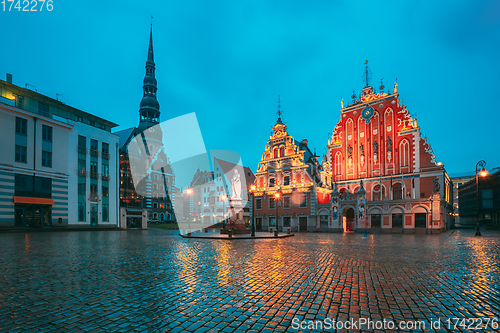 Image of Riga, Latvia. Scenic Town Hall Square With St. Peter\'s Church, Schwabe House, House Of Blackheads During Night Rain. Popular Showplace With Famous Landmarks On It In Bright Evening Illumination In Su