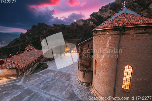 Image of Mtskheta, Georgia. Shio-Mgvime Monastery. Central Part Of Medieval Monastic ShioMgvime Complex In Limestone Canyon In Autumn Sunset. Colorful Altered Sky Above Famous Place