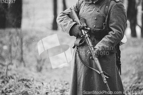 Image of Close up of German military ammunition of a German soldier at World War II. Warm autumn clothes, soldier\'s overcoat, gloves, rifle. Black And White Photo. WWII Copy Space