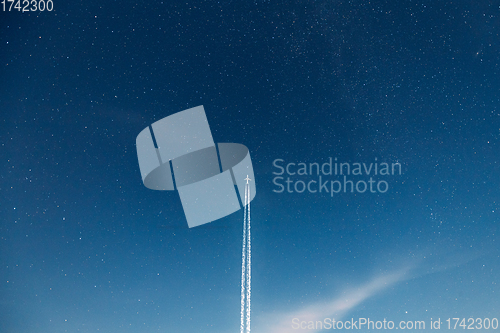 Image of Contrail In Blue Sky. Aircraft Plane In Starry Night Sky Background. Plane Flying Up To Space With Stars On Backdrop. Travel Trip Concept. Copy Space