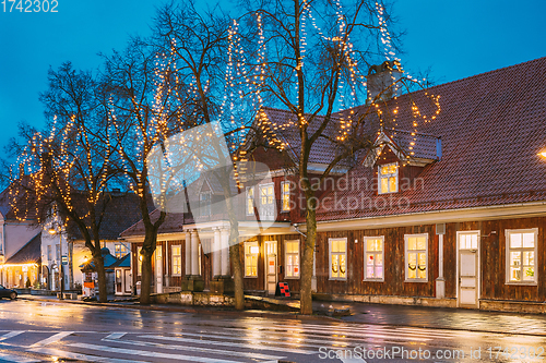 Image of Kuressaare, Estonia. Old Wooden House In Tallinna Street At Evening Night. Street In Fesive Christmas Xmas New Year Illuminations