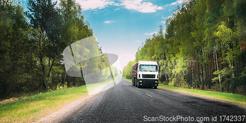 Image of Truck, Tractor Unit, Prime Mover, Traction Unit In Motion On Country Road Through Forest, Freeway. Cloudy Sky Above Asphalt Motorway, Highway. Business Transportation