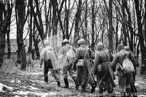 Image of Group Of Re-enactors Dressed As Soviet Russian Red Army Infantry Soldiers Of World War II Marching Along Forest Road At Autumn Season. Black And White. Group Of Re-enactors Dressed As Soviet Russian 
