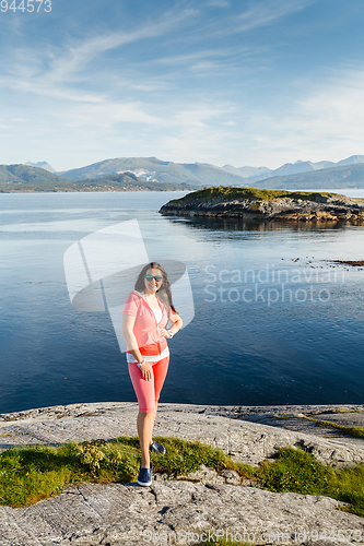 Image of Young woman against view on norwegian fjords