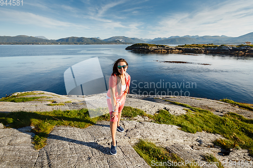 Image of Young woman against view on norwegian fjords
