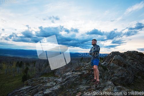 Image of Man standing on top of cliff