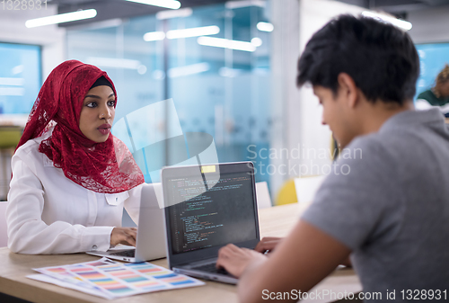 Image of black muslim business woman having a meeting with her indian mal