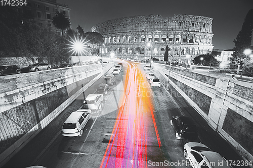 Image of Rome, Italy. Colosseum, Flavian Amphitheatre In Night Time. Night Traffic Light Trails Near Famous World Landmark. All colors except red, pink and yellow are reduced. black and white. Rome, Italy. Co