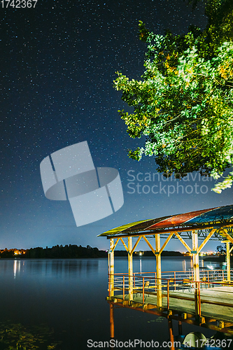 Image of Night Stars Above Lake. Natural Starry Sky Landscape. Wooden Pier.