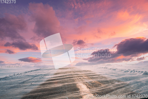 Image of Snow-covered Open Slippy Road During A Snowstorm Blizzard In Winter. Altered Colorful Sunset Sunrise Sky. Dangerous Motion