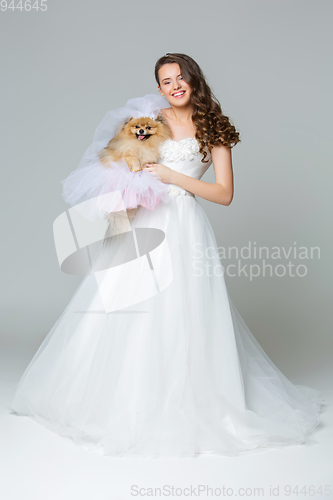 Image of beautiful bride girl with spitz bride on gray background