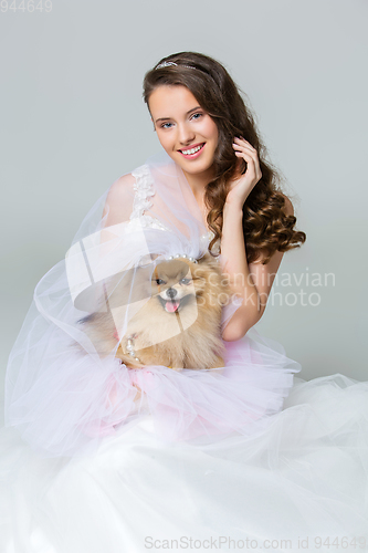 Image of beautiful bride girl with spitz bride on gray background