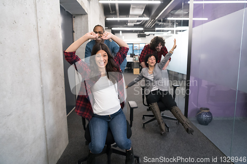 Image of multiethnics business team racing on office chairs