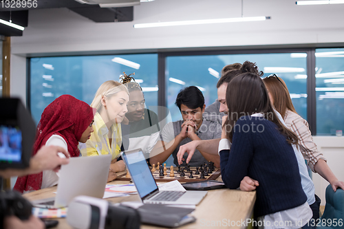 Image of multiethnic group of business people playing chess